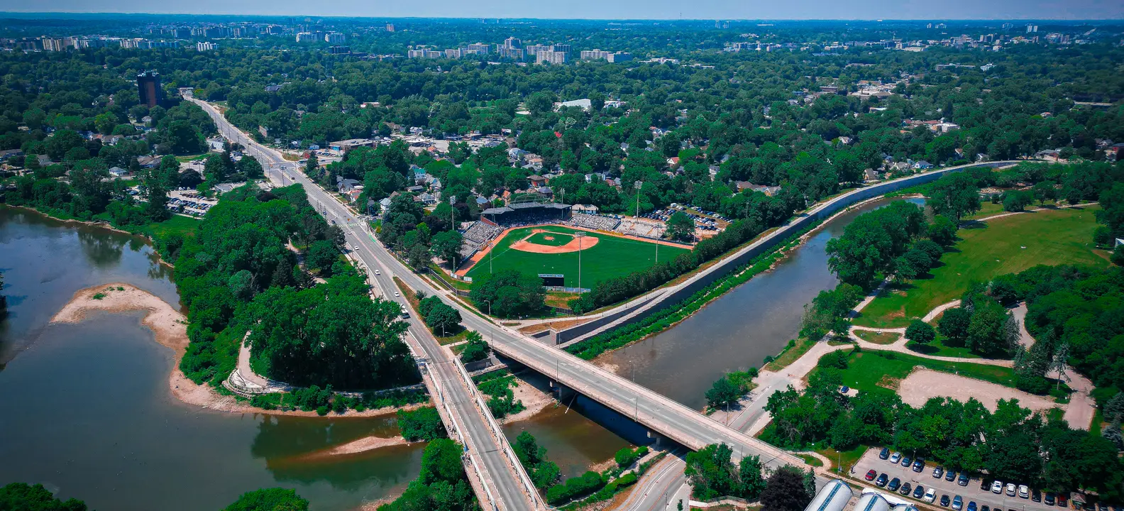 The Forks of the Thames in downtown London, Ontario, with road bridges, park paths and a ballpark beside the river