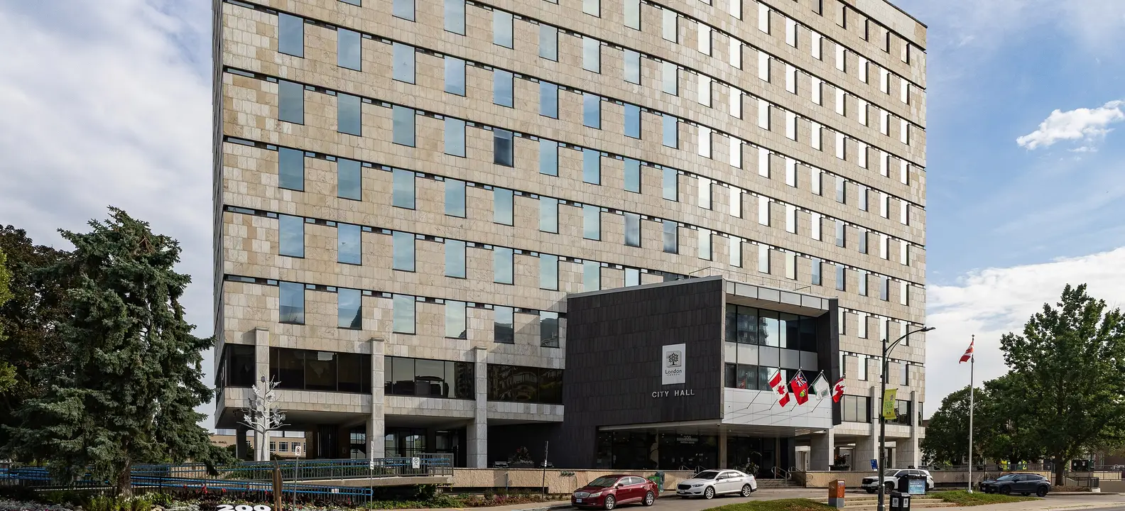 London City Hall on Dufferin Avenue in downtown London, Ontario, with flags at the entrance